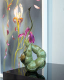 Bronze sculpture of curved green pea pod with a small wren bird inside