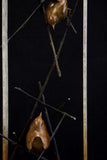 Bronze sculpture of two wren birds in a large frame surrounded by small branches on a black background.