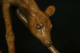 Close-up of a bronze deer head sculpture against a dark background