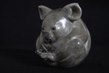 Sculpture of grey Koala curled up in a ball
