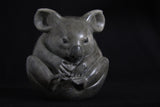 Sculpture of grey Koala curled up in a ball