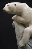 Bronze sculpture of a polar bear on a dark background