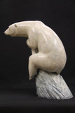 Bronze sculpture of a polar bear on a dark background