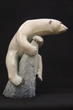 Bronze sculpture of a polar bear clinging to a rock