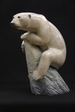 Bromze sculpture of a polar bear on a dark background
