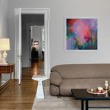 Living room with a brown sofa, coffee table, and colorful abstract painting on the wall.