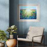 Framed abstract painting on a blue wall with a chair and plants below.