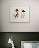 Framed artwork of two stylized birds on a wall above a bed.