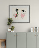 Framed artwork of two stylized birds on a wall above a gray cabinet with decorative items.