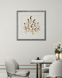 Framed artwork on a wall above a dining table with chairs.