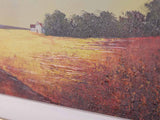 Close-up of a framed landscape painting showing a textured orange and red field with dark trees under a pale sky, with a white moulding