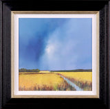 Artwork of a vibrant yellow meadow surrounded by green trees under a cloudy blue sky framed in black and gold moulding.