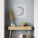 Wooden console table with decorative items against a gray wall with framed artwork.