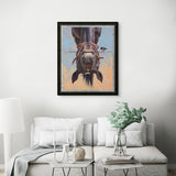 Framed artwork of a horse's face on a wall above a sofa with decorative items.