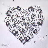 Large group of people forming a heart shape on a snowy ground.