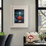 Framed artwork on a wall above a sofa with decorative items in a living room.