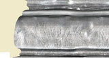 Close-up of a metal cylindrical object with a textured surface on a beige background
