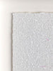 Close-up of a diamond dust white surface with small reflections on a light background