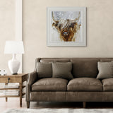 Living room with a brown sofa, framed picture of a Highland cow, and side table with lamp.