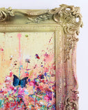 Colorful abstract painting with a 3d butterfly inside an ornate gold frame.