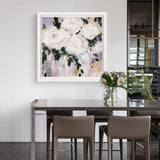 Framed floral artwork on a wall above a dining table with chairs.