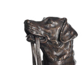 Bronze statue of a dog with a stick on a white background