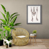 Living room with wicker chair, plants, and a framed picture on the wall.