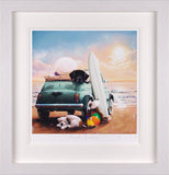A framed art print depicting a whimsical beach scene with a green car carrying a surfboard and a dog, alongside a white dog and a beach ball on the sand under a pastel sky.
