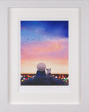 A framed art print featuring a whimsical scene of a round white-headed figure and a small dog sitting in a field of flowers under a colorful sunset sky with birds and a crescent moon.