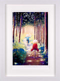 A framed art print depicting a whimsical forest scene with two children riding bicycles down a path, surrounded by tall trees. The print is housed in a thick white frame with a white mat border.