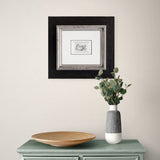 Framed pencil sketch on wall above sideboard with plant pot 