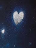 A dark navy blue background filled with fine silver glitter particles forming heart shapes, with soft blue bokeh light effects around the edges.