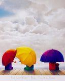 A square art print or painting depicting three small figures seen from behind under large white clouds, each holding a brightly colored umbrella: red, yellow, and purple. The figures stand on a wooden dock, with the phrase 'Whatever the Weather' written below in cursive on a white border.