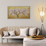 Living room with a woven bench, white cushions, and a decorative painting of a cherry blossom tree.