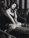 Woman sitting on a couch holding a phone in a black and white painting.