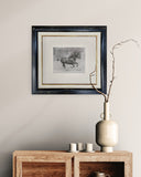 framed sketch of horse galloping on a wall above a wooden side board