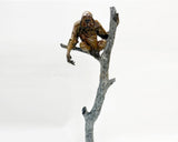 Bronze sculpture of orangutan perched on a tree branch