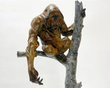 Bronze sculpture of orangutan perched on a tree branch