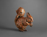 Bronze squirrel sculpture on a grey background