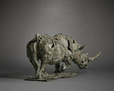 Bronze sculpture of a rhinoceros on a gray background