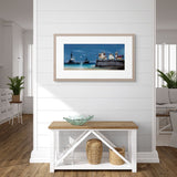 Framed artwork of a lighthouse scene on a wall in a living room.