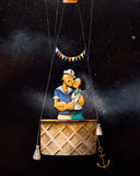 Statue of a man and woman in a hot air balloon against a starry night sky.