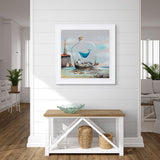 Framed artwork of a whale in a bottle on a wall above a wooden bench.