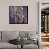 Living room with a gray sofa, round coffee table, and framed elephant painting on the wall.