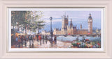 A framed panoramic painting of London's Houses of Parliament and Big Ben, showing a riverfront scene with pedestrians, trees, and flowers, set in a light-colored frame.