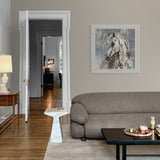 framed painting of horse above a sofa and wooden coffee table