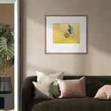 Framed artwork on a wall above a sofa with decorative pillows