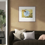 Framed artwork on a wall above a sofa with decorative pillows