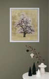 Framed artwork of a tree with pink blossoms on a beige background, displayed on a wall above a small decorative table.