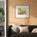 Framed artwork of birds on a wall above a sofa with decorative pillows.